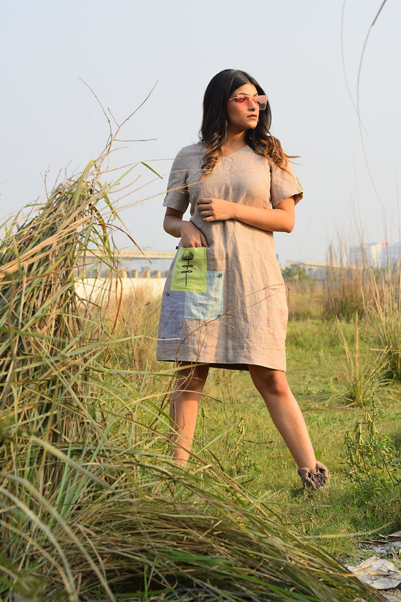 Linen dress with contrast hand-embroidered pockets.